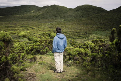 Rear view of man and woman walking on mountain