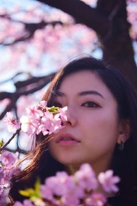 Close-up portrait of woman with pink flowers