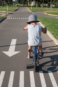 Boy riding bicycle on road