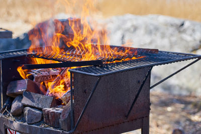 Fire in a rusty vintage grill outdoor with blurred background.