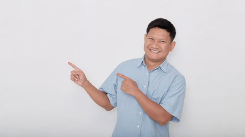 Portrait of smiling man standing against white background