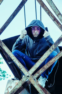 Low angle view of man sitting outdoors