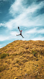 Man jumping against sky