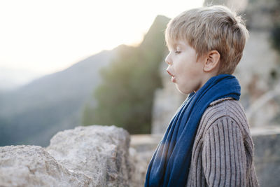 Side view of boy standing on mountain