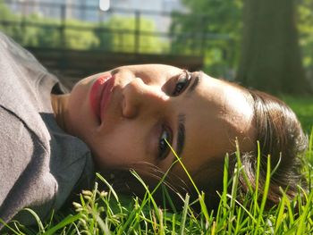 Portrait of mid adult woman lying on grassy field