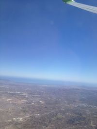 Aerial view of landscape and sea against clear blue sky