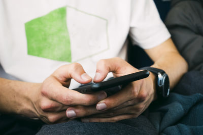 Midsection of man using mobile phone