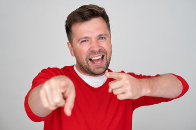 Portrait of young man gesturing against white background