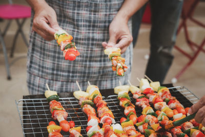 Midsection of man preparing food on barbecue grill