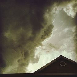 High section of built structure against cloudy sky