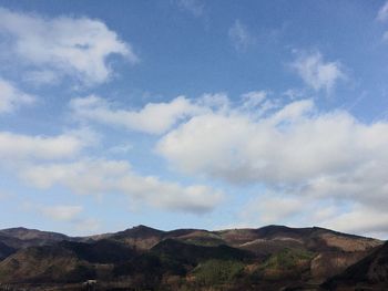Scenic view of mountains against cloudy sky