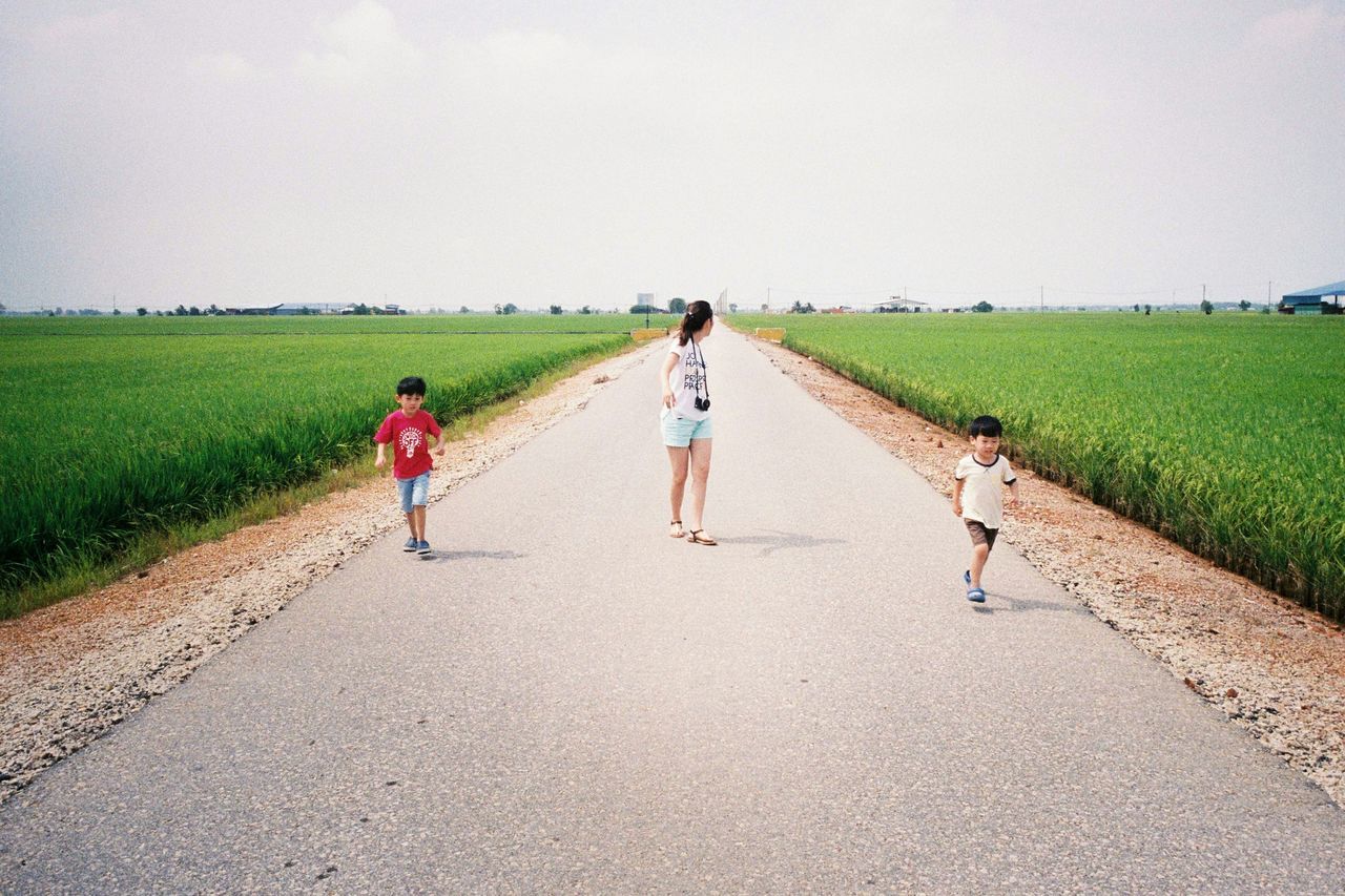 full length, lifestyles, leisure activity, walking, grass, togetherness, rear view, men, boys, clear sky, field, the way forward, childhood, copy space, bonding, person, landscape, girls