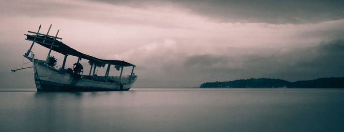 Fishing boat in sea against sky