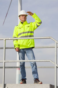 Low angle view of man standing against railing