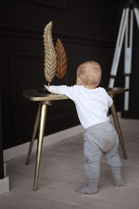 Rear view of woman standing against wall