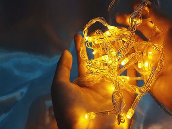 Close-up of woman holding illuminated lighting equipment
