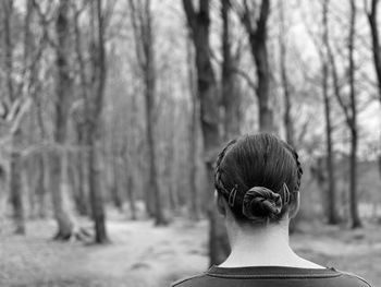 Black and white monochrome rear view of woman walking in woodlands