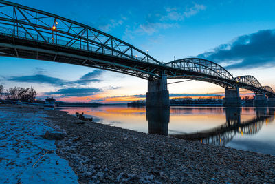 Bridge over river against sky during sunset
