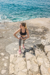 Woman running training on sea coastline under sunlight in sunny summer day. sport, run, health.