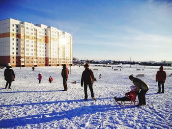 People walking on snow covered city