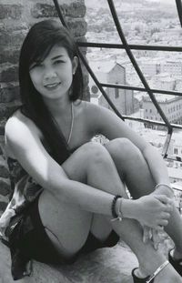 Portrait of smiling young woman sitting outdoors