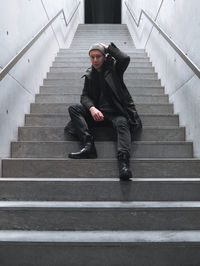 Low angle view of man sitting on staircase