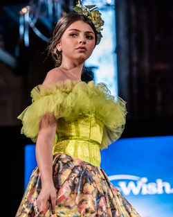 Young woman looking away while standing outdoors