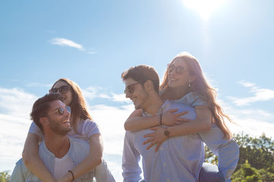 Group of young friends walking in a park while smiling - happy young group of friends