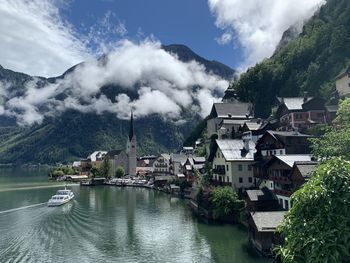 Scenic view of river by town against sky