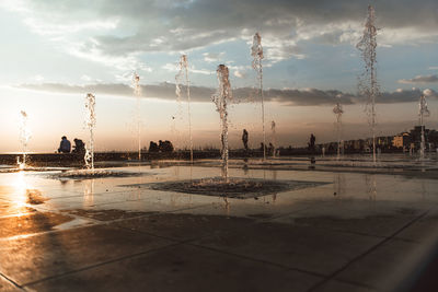 Scenic view of wet shore against sky during sunset