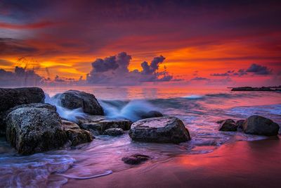 Rocks on sea shore at sunset