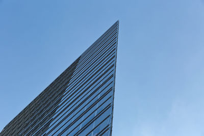 Low angle view of modern building against blue sky