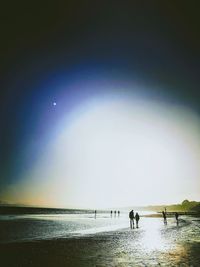 Silhouette man on beach against sky at night