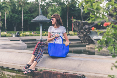 Girl in the park holding a bag made of exotic python skin