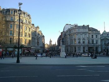 People on street in city against clear sky
