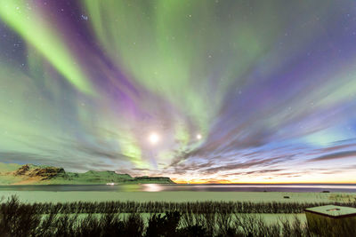 Scenic view of lake against sky at night