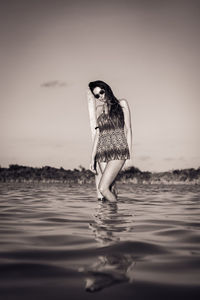 Woman standing at beach against clear sky