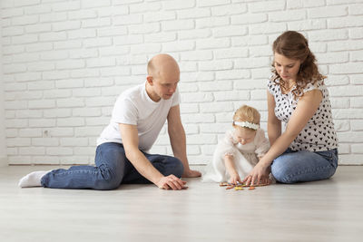 Couple with daughter playing puzzle at home