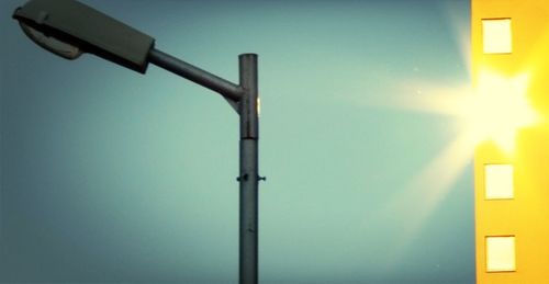 Low angle view of street light against blue sky