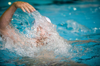 Person splashing water in swimming pool