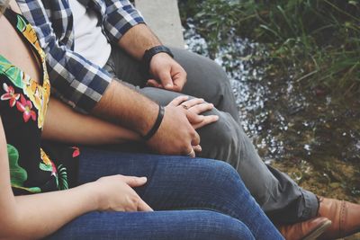 Low section of couple sitting on bench