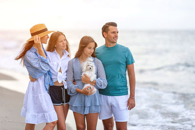 Rear view of couple standing at beach