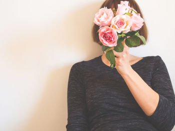 Midsection of woman holding rose bouquet