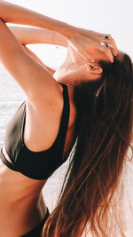 Midsection of woman with hair at beach