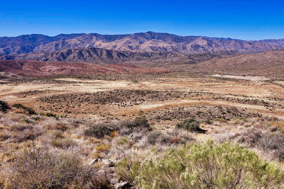 Scenic view of mountains against blue sky