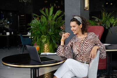 Young woman using laptop at cafe