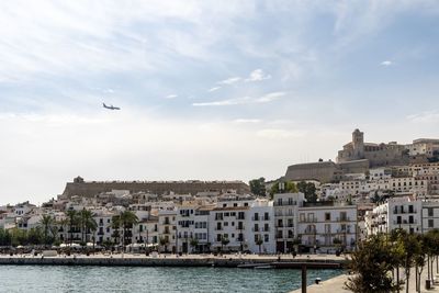 Buildings by sea against sky in city