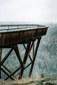 Old bridge over trees in foggy weather