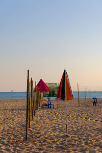 Lifeguard hut on beach against clear sky during sunset