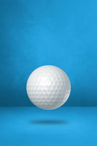 Close-up of ball on table against blue wall